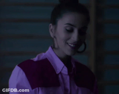 Woman In Purple Shirt And Earrings Smiling GIF