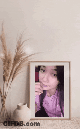 Woman In Purple Shirt Framed Next To Vase GIF