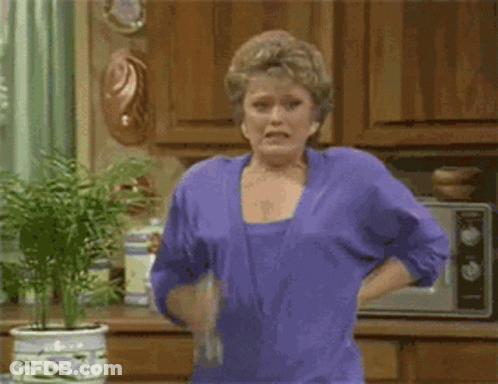 Woman In Purple Shirt Holding Water Bottle In Kitchen GIF