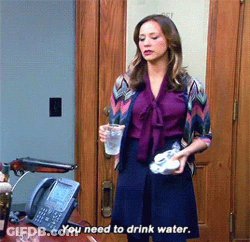 Woman In Purple Shirt Holding Water Cup GIF