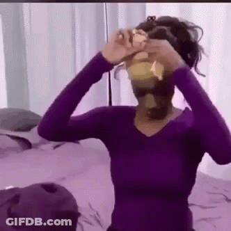 Woman In Purple Shirt Holding Yellow Object GIF