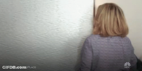 Woman In Purple Shirt Looking At Wall GIF