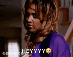 Woman In Purple Shirt Making Funny Face Saying Hey GIF