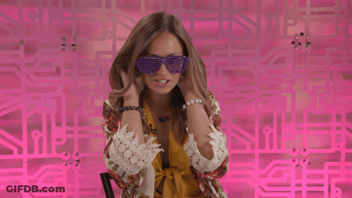 Woman In Purple Sunglasses In Front Of Pink Wall GIF