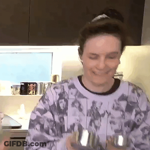 Woman In Purple Sweater Holding Dumbbells In Kitchen GIF