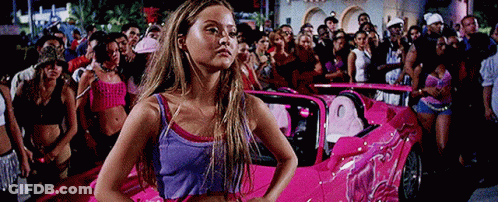 Woman In Purple Tank Top In Front Of Pink Car GIF