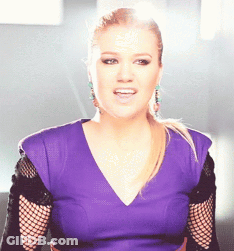 Woman In Purple Top And Black Fishnet Sleeves Singing GIF