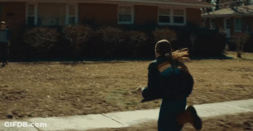 Woman In Rainbow Jacket Running GIF
