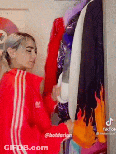Woman In Red Adidas Jacket By Closet GIF