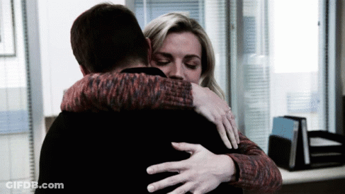 Woman In Red And Black Sweater Hugging Man In Black Shirt GIF