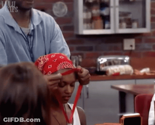 Woman In Red Bandana Helped By Man In Kitchen GIF
