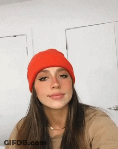 Woman In Red Beanie Taking Selfie In Front Of Door GIF