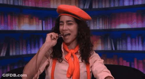 Woman In Red Beret And Orange Suspenders Eating GIF