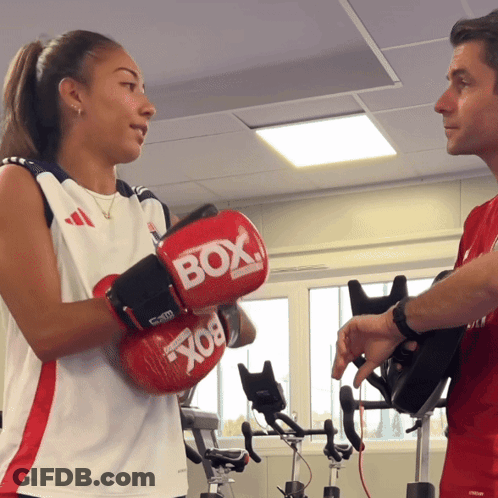 Woman In Red Boxing Gloves Talking To Man GIF