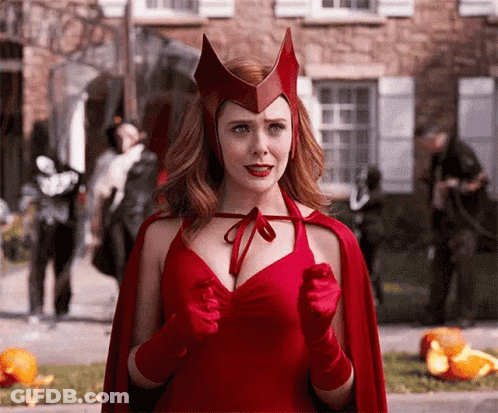 Woman In Red Cape And Gloves Standing In Front Of Building GIF