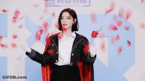 Woman In Red Cape Holding Rose By Sign Saying Girl GIF