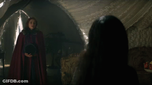 Woman In Red Cape Talking To Woman In Dark Room GIF