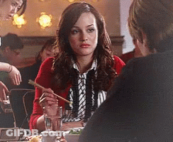 Woman In Red Cardigan Sitting At Table With Chopsticks GIF