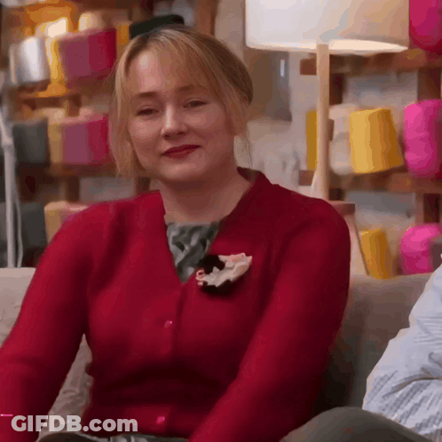 Woman In Red Cardigan With Flower Pin GIF