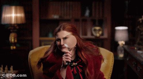 Woman In Red Coat Holding Magnifying Glass GIF
