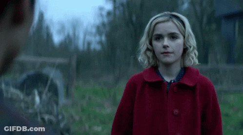 Woman In Red Coat Looking At Man In Field GIF