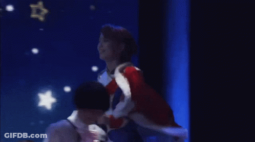 Woman In Red Coat On Stage With Blue Screen GIF