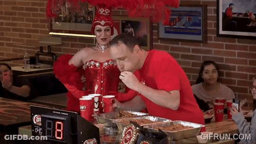 Woman In Red Corset And Man In Red Shirt Eating Pizza GIF