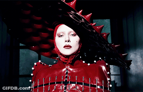 Woman In Red Costume With Spikes And Nails GIF