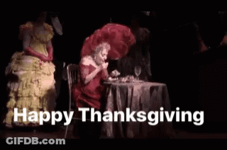 Woman In Red Dress At Table Saying Happy Thanksgiving GIF