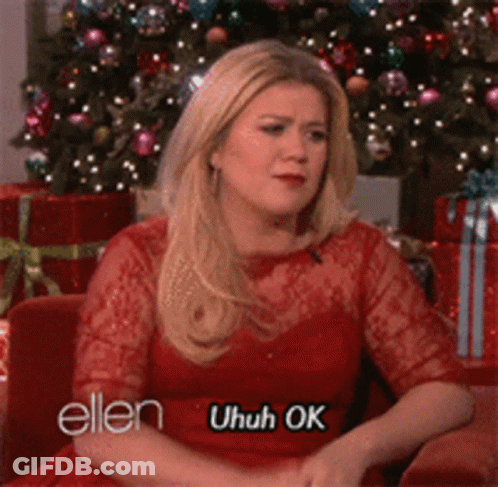 Woman In Red Dress By Christmas Tree Saying Uhuh Ok GIF