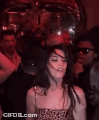 Woman In Red Dress Dancing In Dark Room With Group GIF