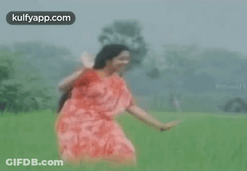 Woman In Red Dress Dancing In Green Field GIF