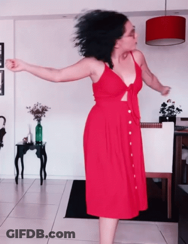 Woman In Red Dress Dancing In Living Room GIF