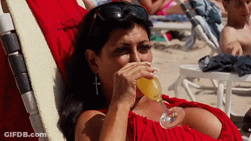 Woman In Red Dress Drinking On Beach Chair GIF