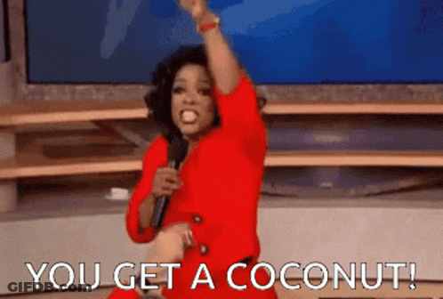 Woman In Red Dress Holding Microphone Says You Get A Coconut GIF