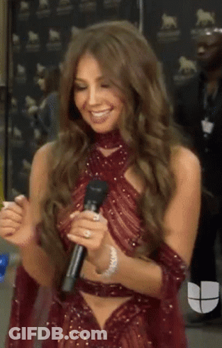 Woman In Red Dress Holding Microphone Smiling GIF