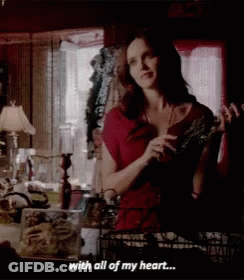 Woman In Red Dress Holding Plant GIF
