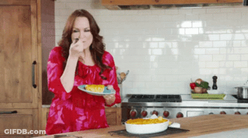 Woman In Red Dress Holding Plate Of Food GIF