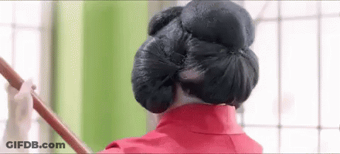 Woman In Red Dress Holding Wooden Stick In Hair GIF