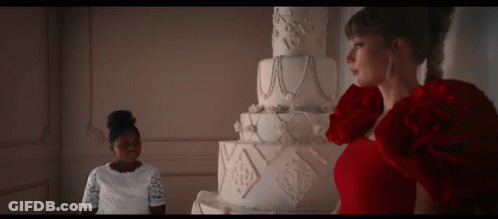 Woman In Red Dress In Front Of Large White Cake GIF