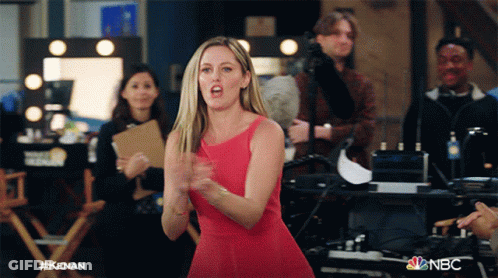 Woman In Red Dress In Front Of NBC Sign GIF