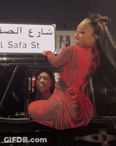 Woman In Red Dress In Front Of Safa St Sign GIF