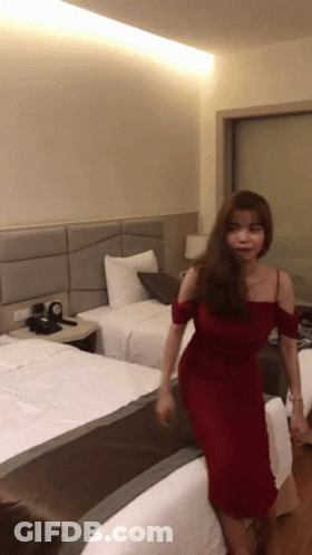 Woman In Red Dress In Hotel Room GIF
