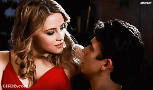 Woman In Red Dress Kissing Man On Cheek GIF