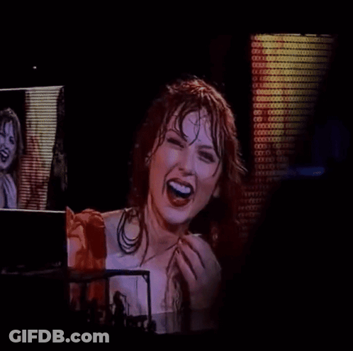 Woman In Red Dress Laughing In Front Of Screen GIF