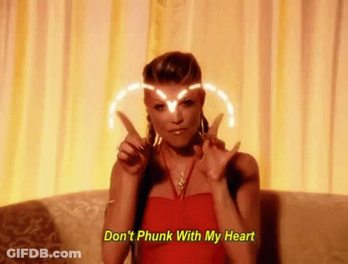 Woman In Red Dress Making Peace Sign On Couch GIF