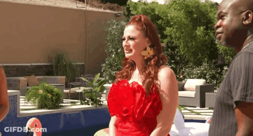 Woman In Red Dress Next To Man And Flamingo Float GIF