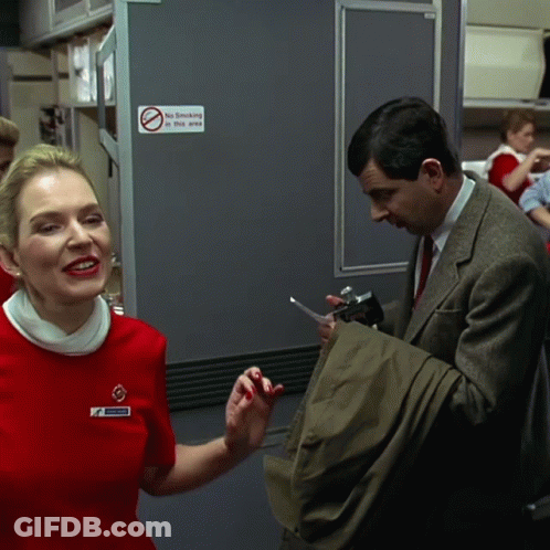 Woman In Red Dress Next To Man In Suit No Smoking Sign GIF