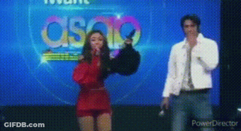 Woman In Red Dress Next To Man In White Jacket GIF