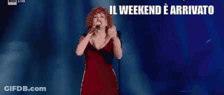 Woman In Red Dress Singing Into Microphone Il Weekend E Arrivato Che Sia Benedetto GIF
